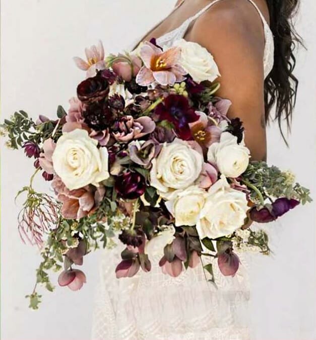 Cropped photo of bride with beautiful burgundy and white bouquet